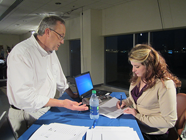 Journalism instructor Stephen Puddicombe gives last-minute tips to election coverage co-anchor Gena Holley. Photo: Beth Hendry