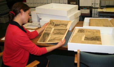 Photo of Research assistant Laurie Chase examining The Great War Diaries – a collection of newspaper clippings from the First World War that are being digitized. They are part of an extensive collection of material about the war housed in the Dalhousie Archives and would be used for the Geographic Information System project.