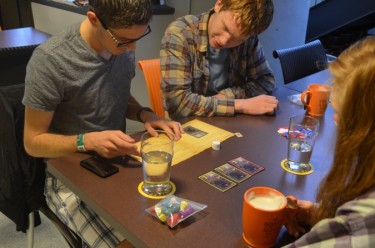 Three people play a board game.