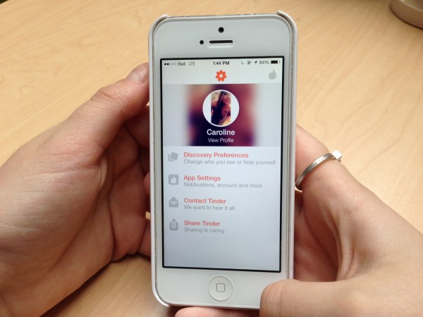 Caroline Aquanno checks out her profile on Tinder. Photo: Hanna McLean
