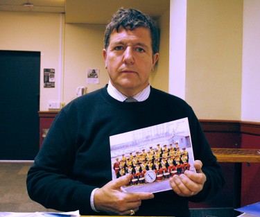 Bob Martin holds the picture of his high school band which was taken around the start of his abuse.