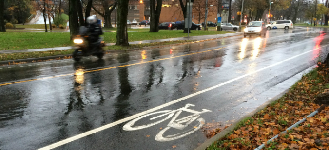 A motorcycle and car drive beside a bikelane. Photo: Nikki Jamieson