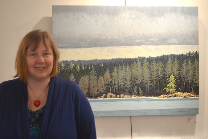 Adriana Afford stands in front of a painting