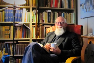 Father Thorne with Tea: Father Thorne sits in his favourite spot in his office for a moment of calm. Photo: Leah Gerber